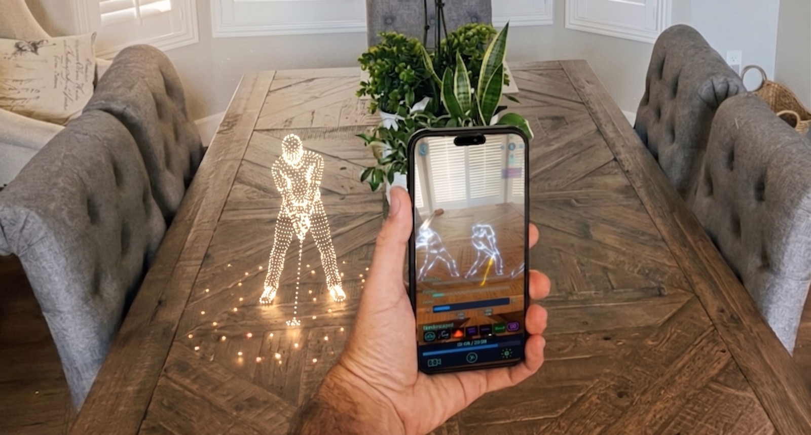 Hand holding an iPhone running SkyRender AR, a glowing drone-show figure previewed at true scale on a dining table