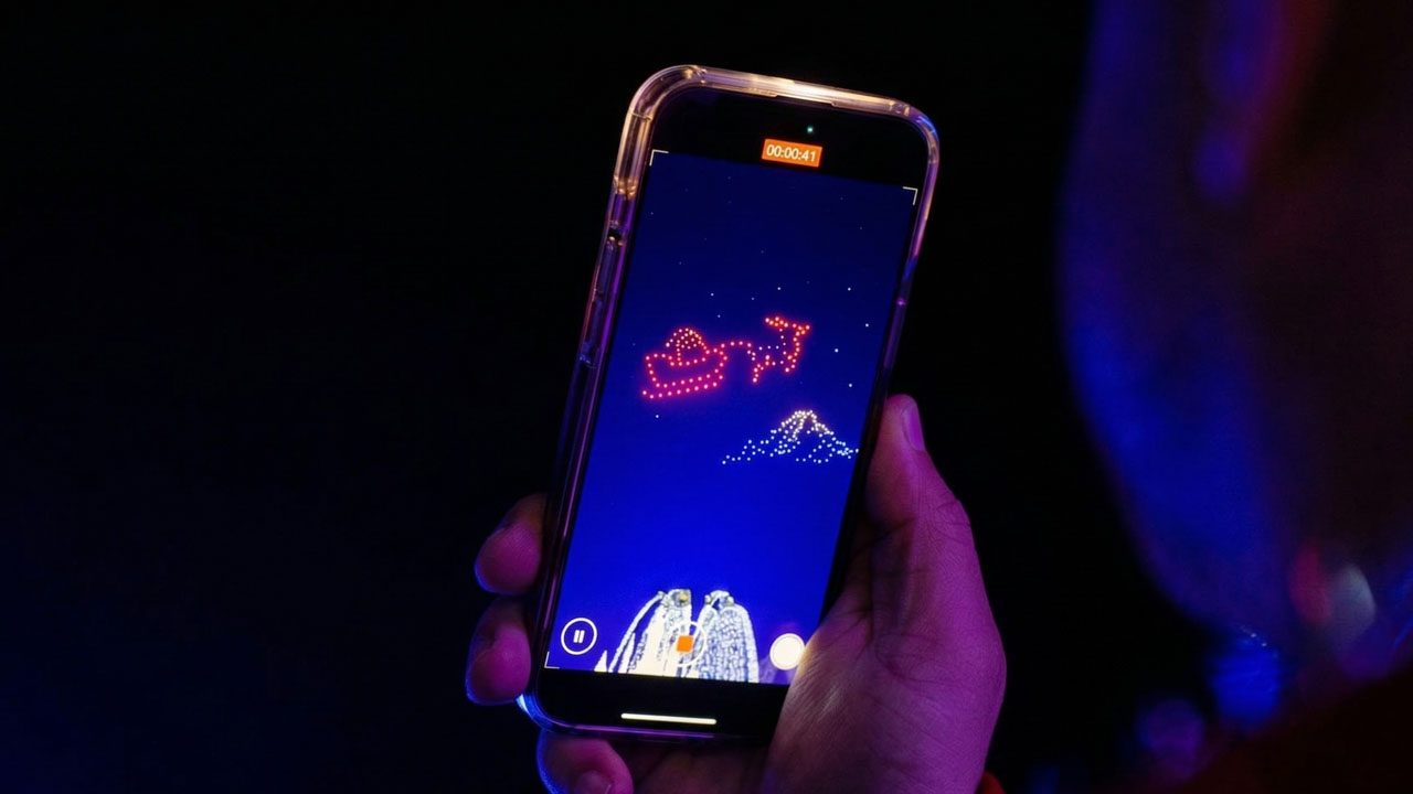Crowd filming Creative Skies Christmas drone show on phones — viral holiday event